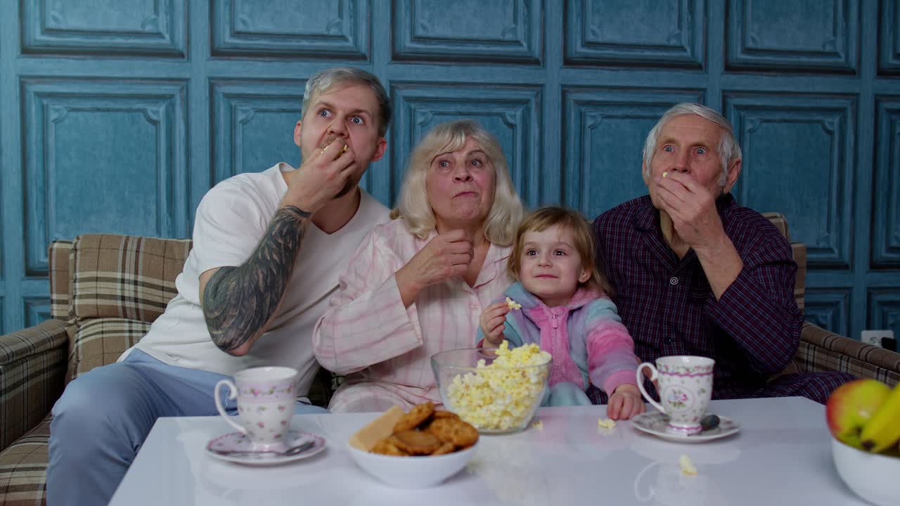 다세대 가족은 집에서 어린 소녀와 함께 tv를보고 만화 코미디 영화를 보고 웃고 있습니다.