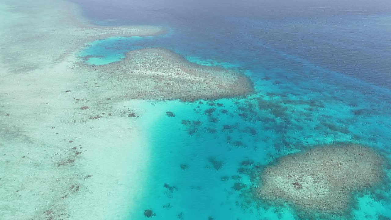 モルディブのサンゴ礁とターコイズブルーのラグーンをドローンで空撮した4K映像