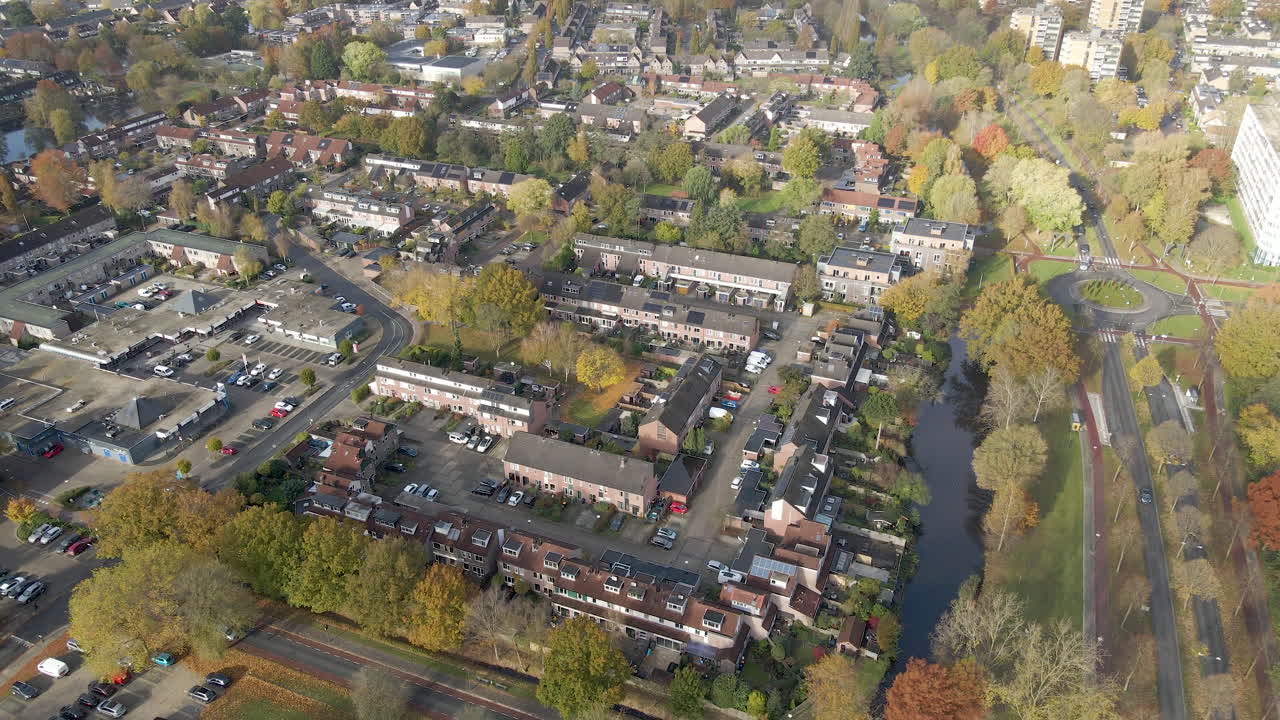 Veduta aerea di un quartiere residenziale con pannelli solari su diversi tetti - drone che vola all'indietro.
