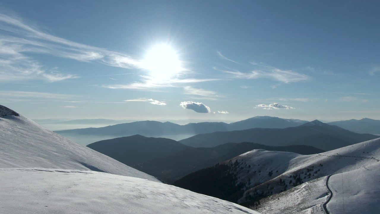 Snowboarder che camminano verso il bordo di una montagna innevata con gli snowboard in mano