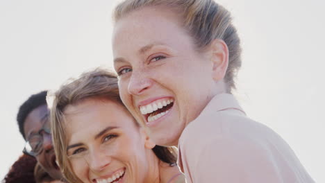 Head-And-Shoulders-Portrait-Of-Smiling-Young-Friends-Outdoors-Together-Against-Flaring-Sun