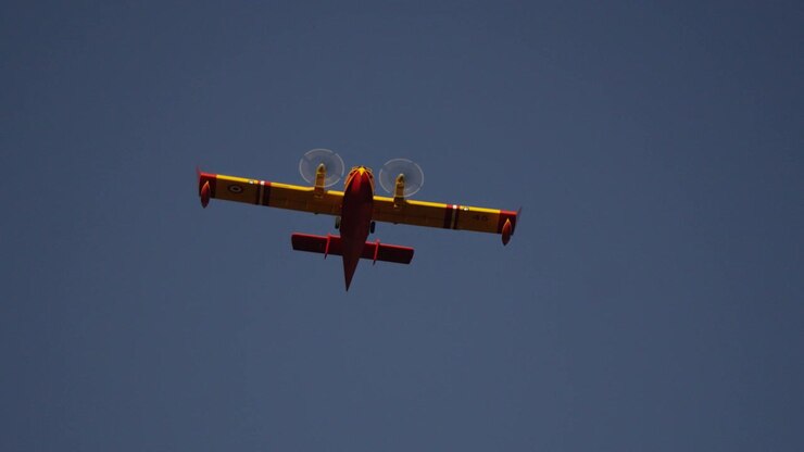 Low Angle Close Up of Canadair Firefighting Plane Aircraft Flying in Blue Sky