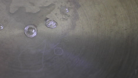 close-up view of bubbles forming on the surface of a stainless steel pan