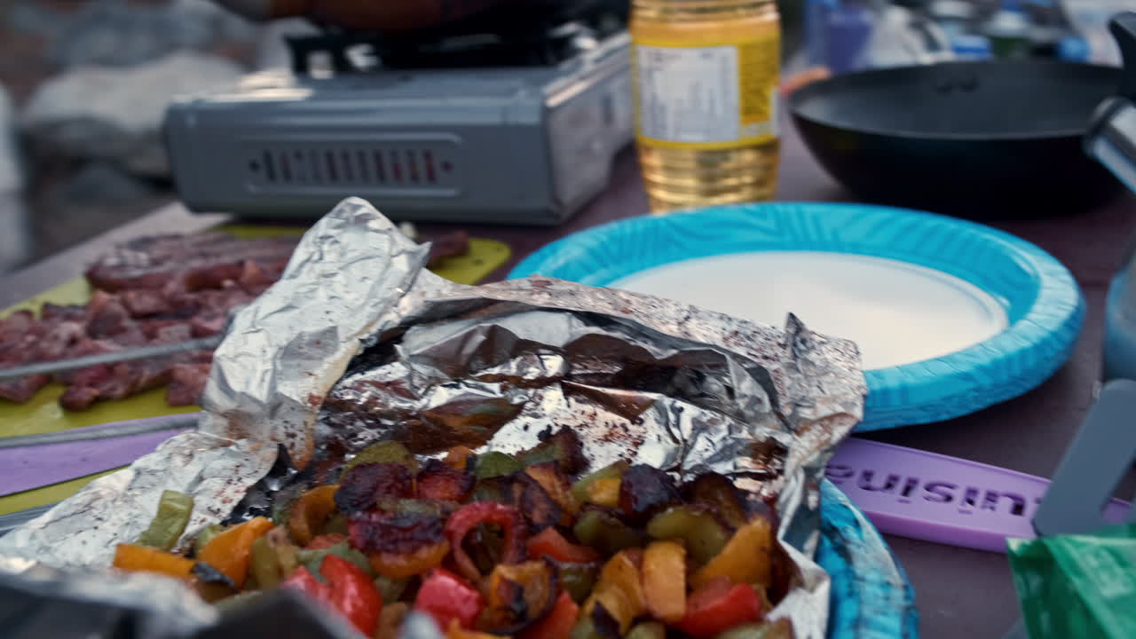 cocinar y ensamblar bistec marinado y verduras en la estufa del campamento durante el día