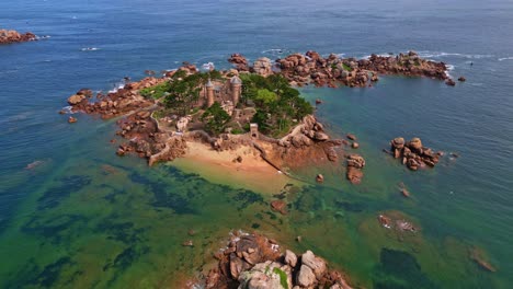 vertically tilted smooth panoramic drone movement around the neo-medieval costaérès castle with rocky coastline, trégastel, côtes-d'armor, brittany, france.