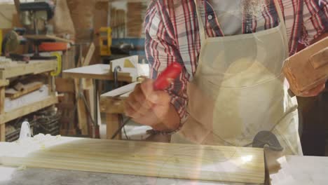 animation of data processing over caucasian male carpenter working in workshop