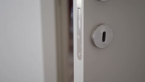 close up of a white door with a silver handle and keyhole
