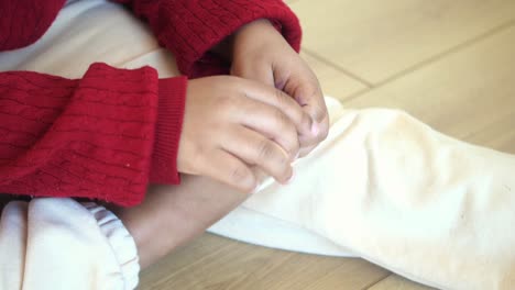 un primer plano de las manos de un niño sentado en el suelo