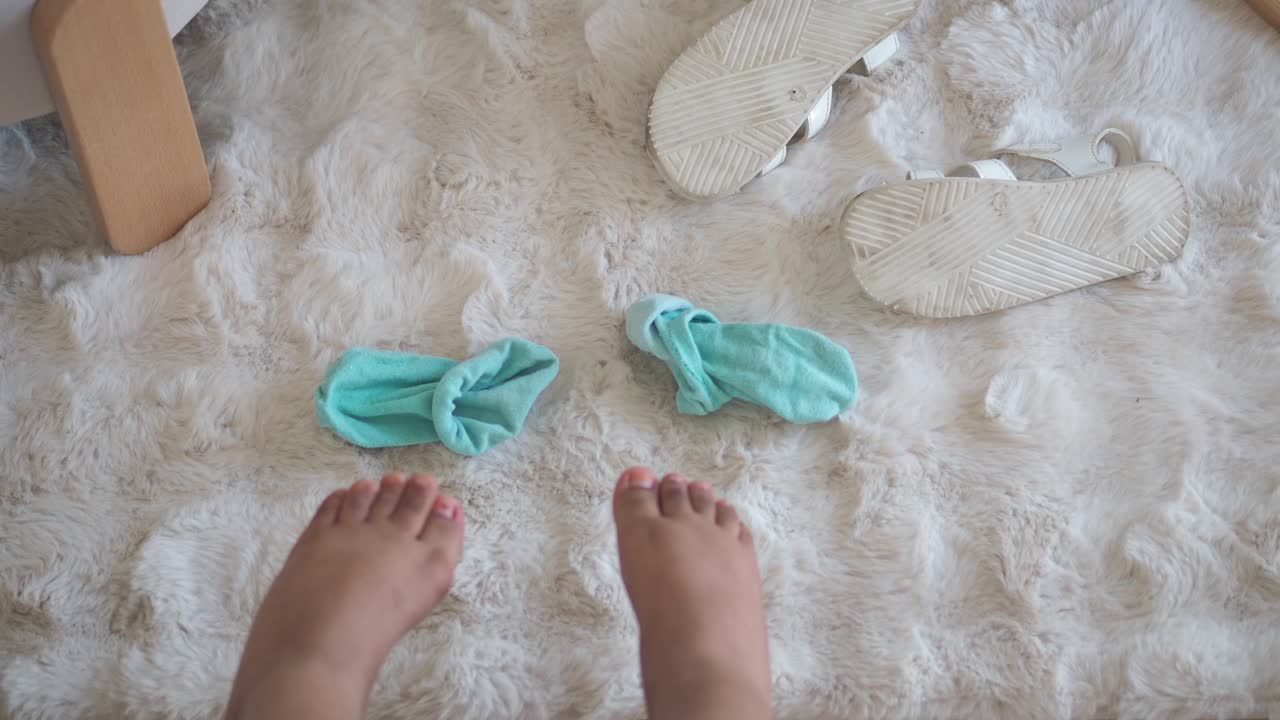 Fødder med sokker og sandaler på et gulvtæppe