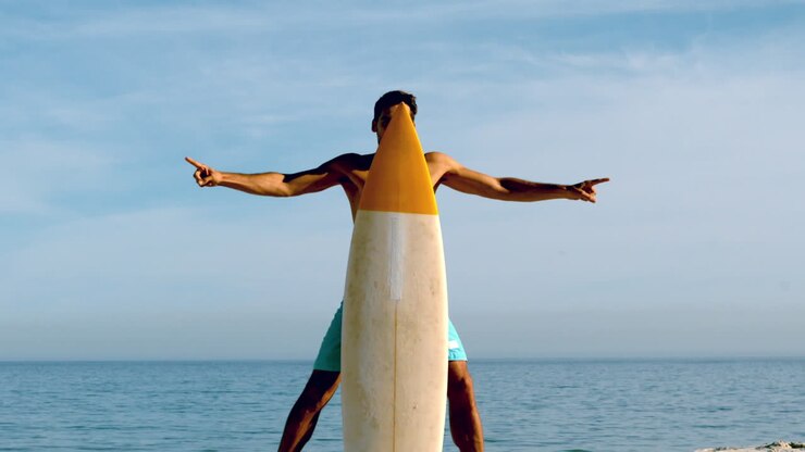 Uomo attraente che si nasconde dietro la sua tavola da surf