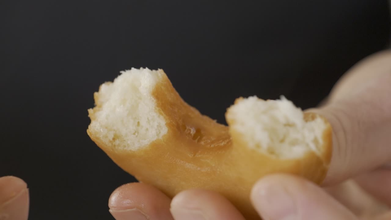맛있는 홈메이드 도넛을 부수고 있는 손 클로즈업