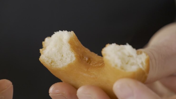 Close-up of hands breaking open a delicious homemade donut