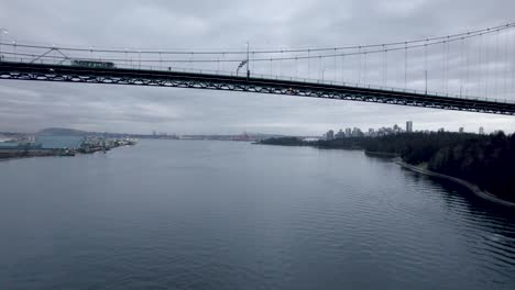 drone flying under lions gate bridge, vancouver in canada