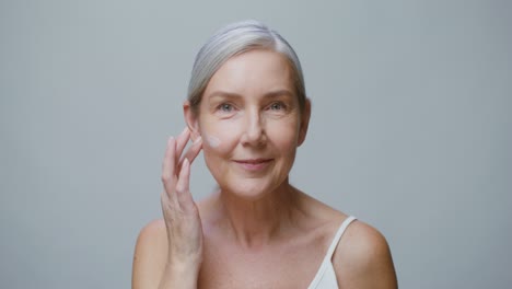 mature woman applying face cream