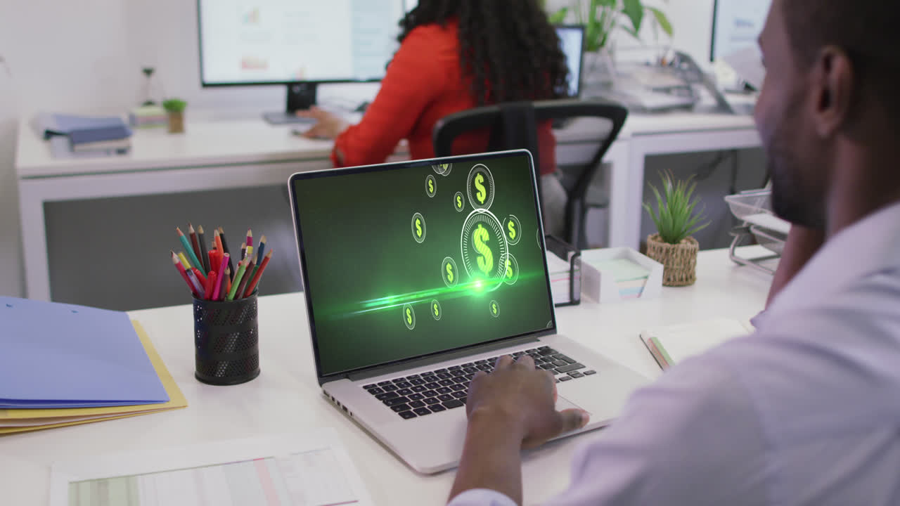 video de un hombre afroamericano trabajando en una computadora portátil con dólares en la pantalla