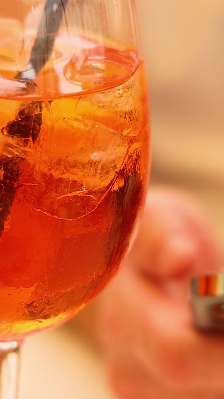 Aperol Spritz com uma pessoa usando um smartphone