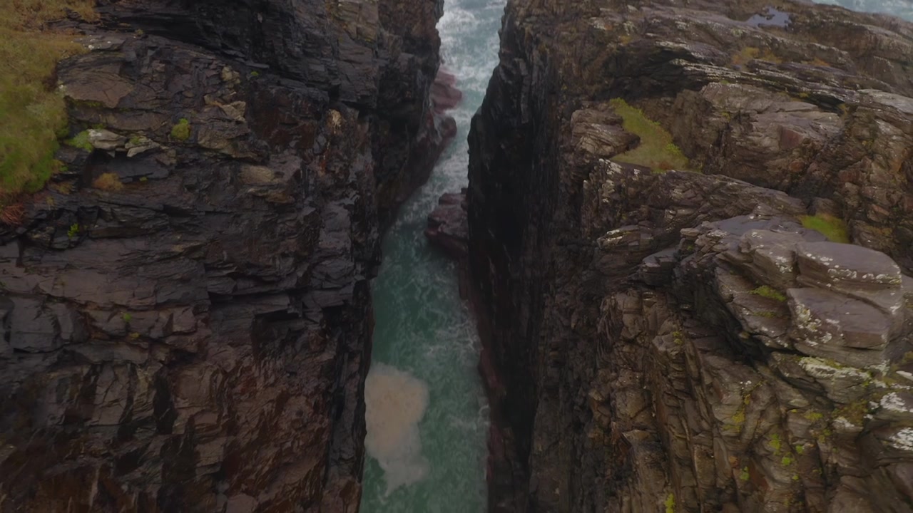 Top-down dynamic aerial of Hell’s Hole at Malin Head, Ireland’s northernmost point