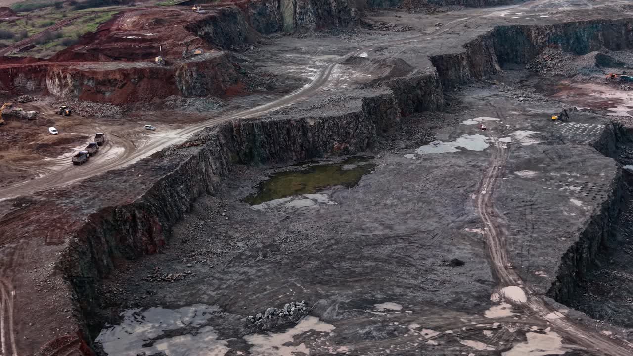 Granite quarry site with machinery and uneven terrain in operation