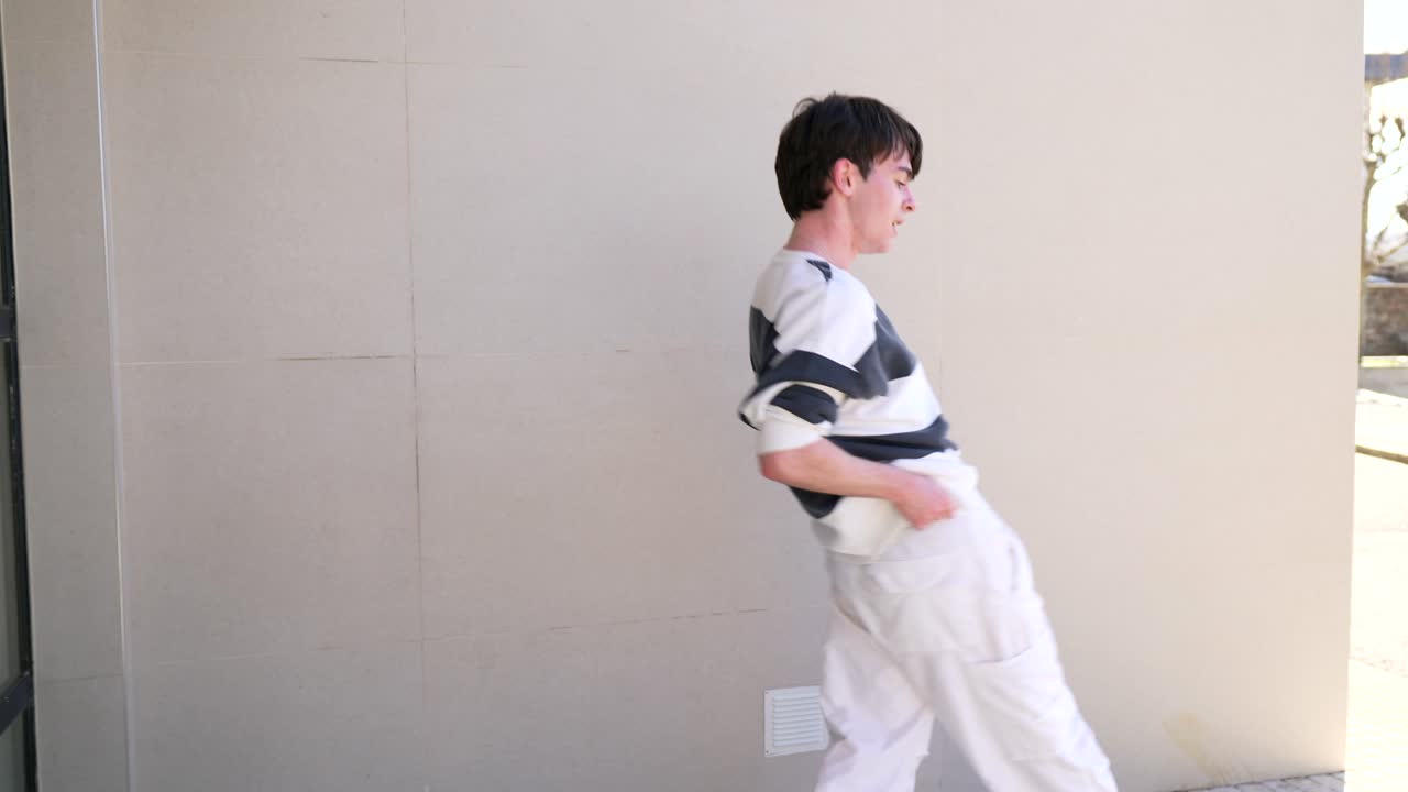 Man in striped shirt and white pants outdoors