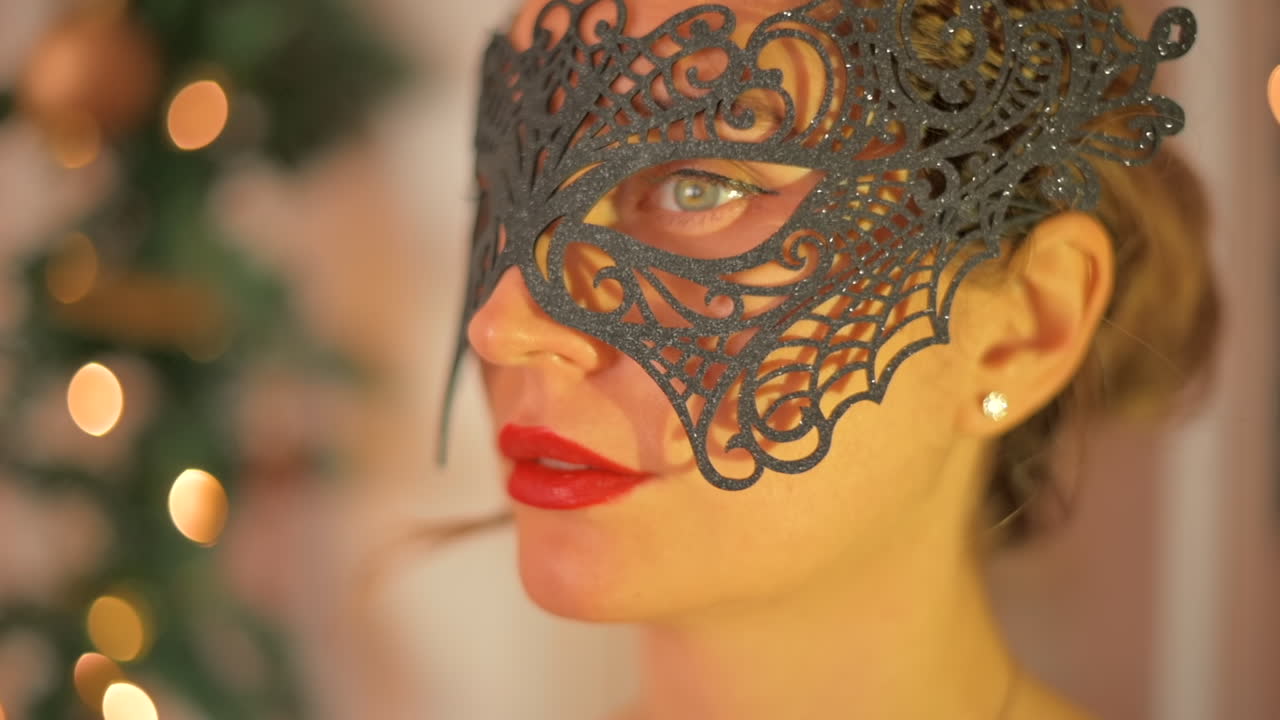 Primo piano di una donna con labbra rosse e occhi azzurri che indossa una maschera nera