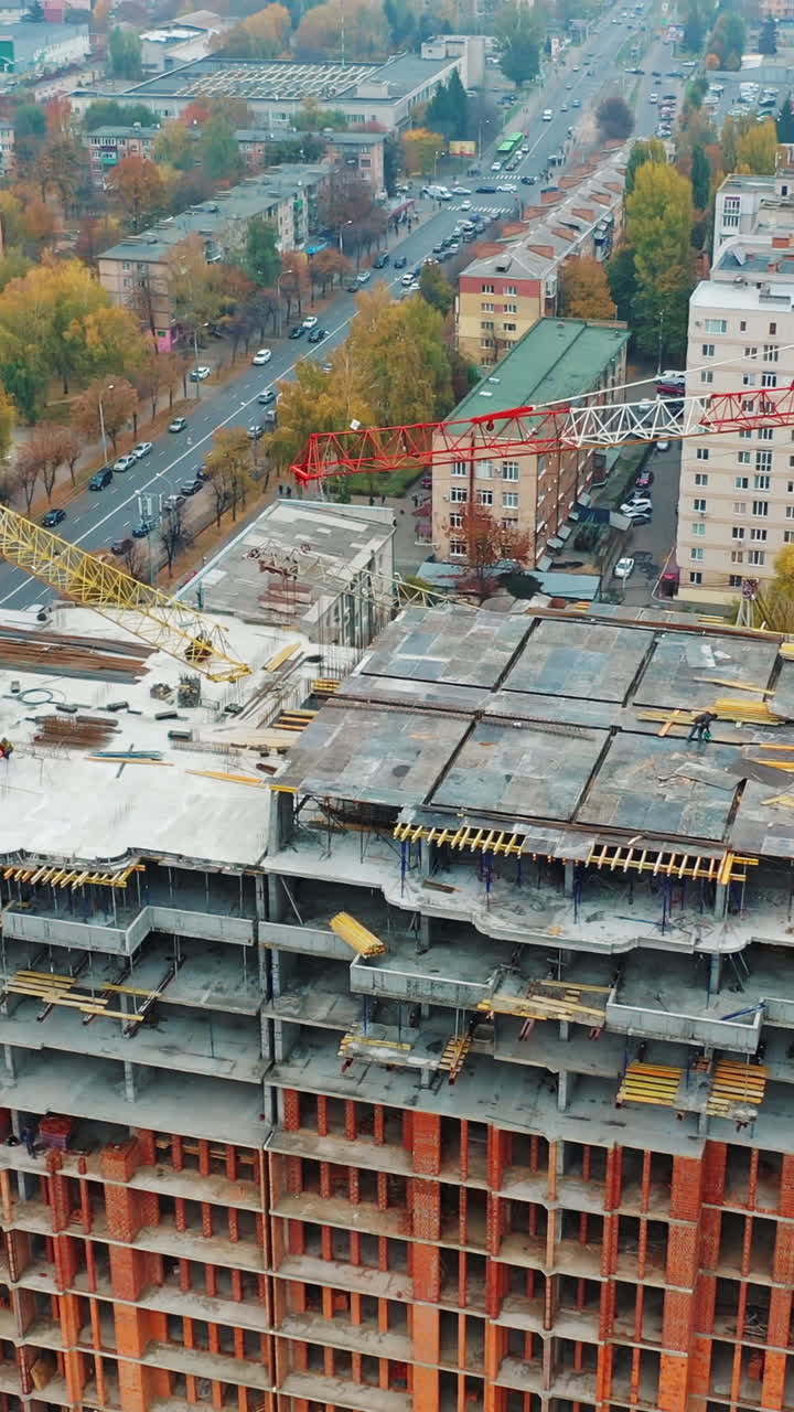 Labor working at construction site. Aerial shot of the building in the process of construction