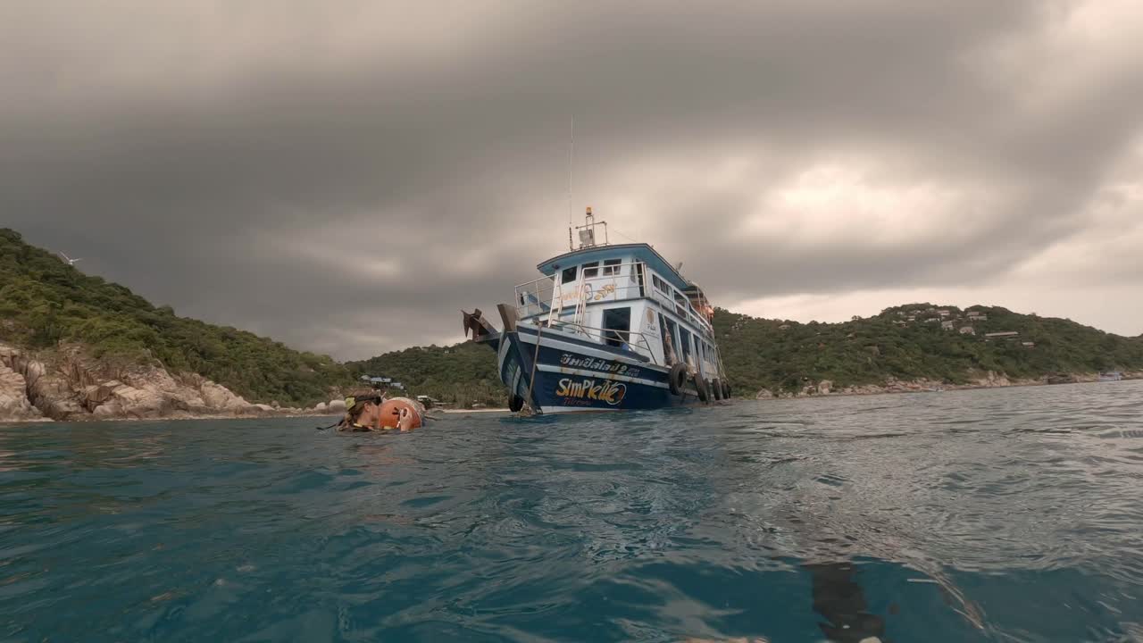 una chica rubia está nadando en el océano