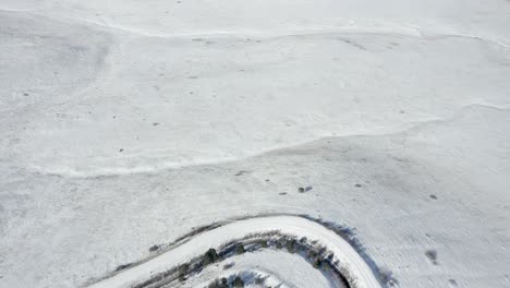 Aerial-view-pans-up-from-trail-to-reveal-snow-covered-Boulder-Colorado-mountains