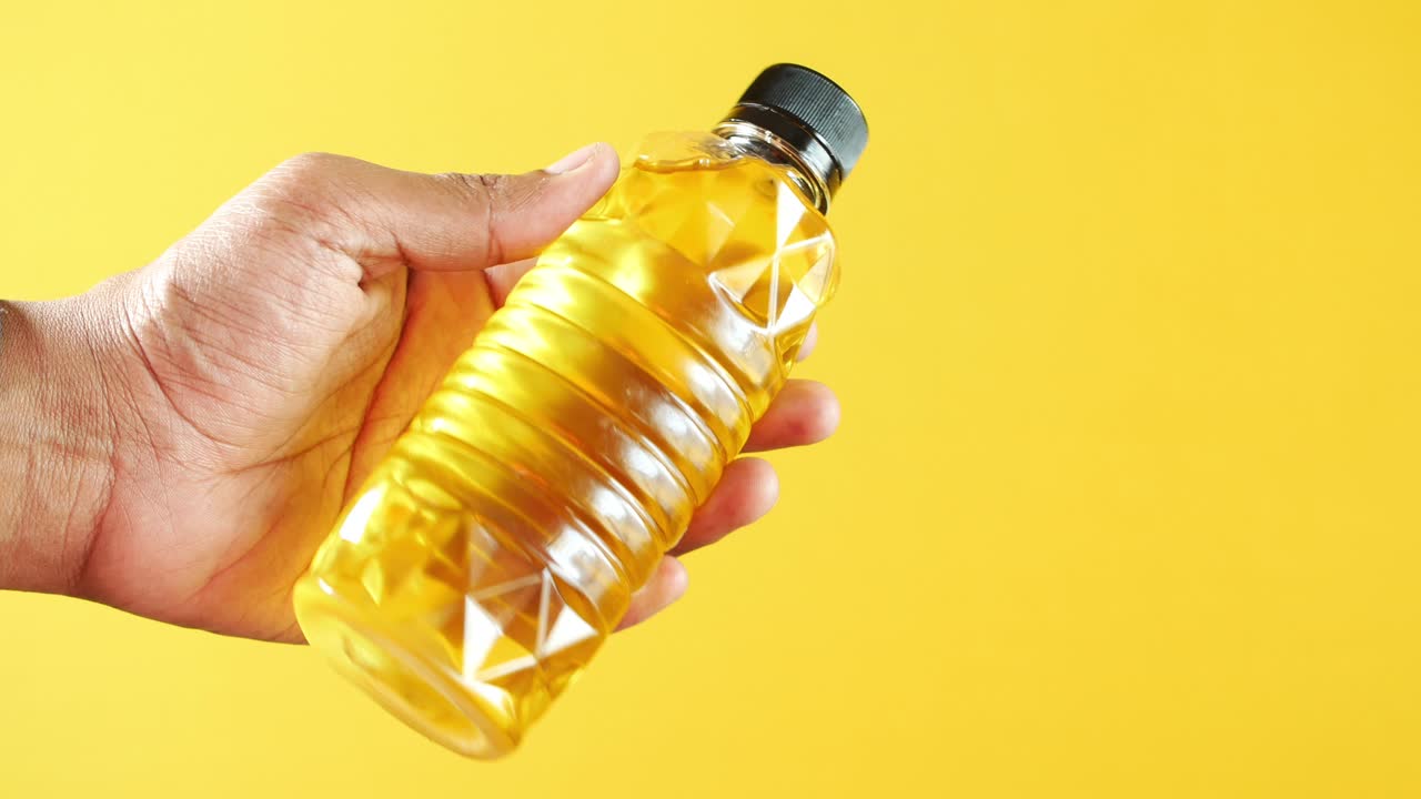 요리 기름 한 병 을 들고 있는 손