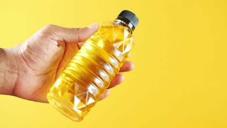 hand holding a bottle of cooking oil