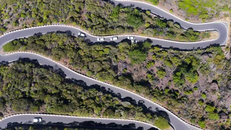 Winding-road-with-sharp-corners-on-Tenerife-during-sunny-day,-top-down