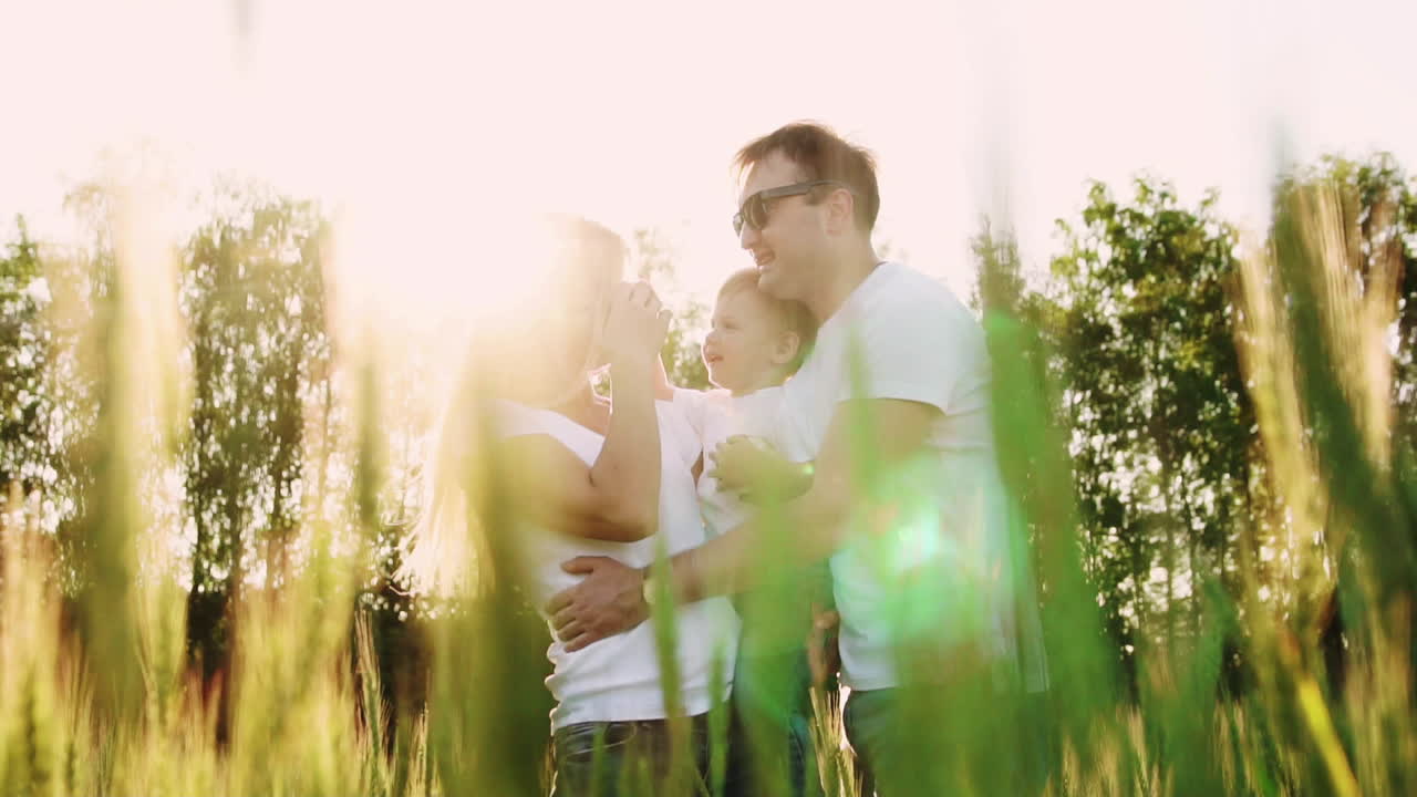 어머니 와 아버지 가 아들 을 안아주고 있다