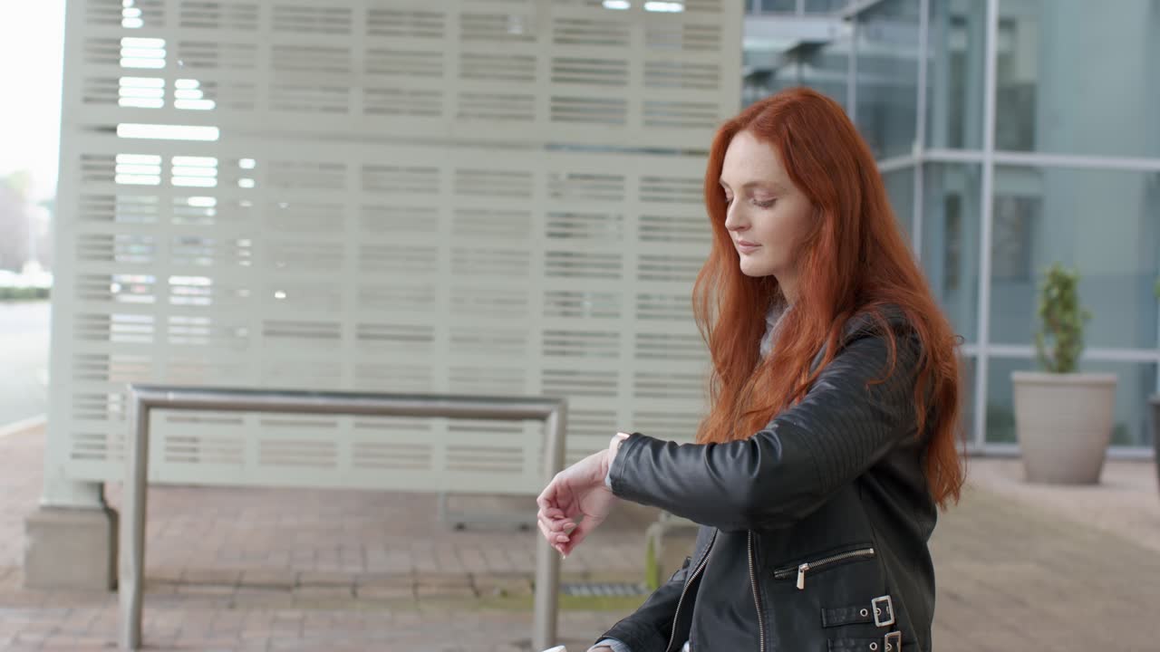 Donna sui 20 anni seduta su una panchina con un caffè in mano che aspetta una riunione e controlla l'ora, fuori dall'ufficio, spazio per il testo