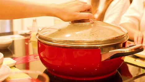 preparing sukiyaki in a red pot