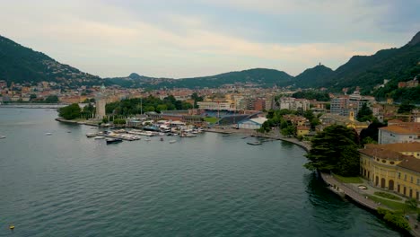 4k aerial drone video of the marina and soccer stadium on the shore of beautiful lake como, italy