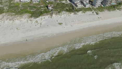 video de dron siguiendo a una pareja caminando por la playa revelando la costa en el cabo san blas, florida