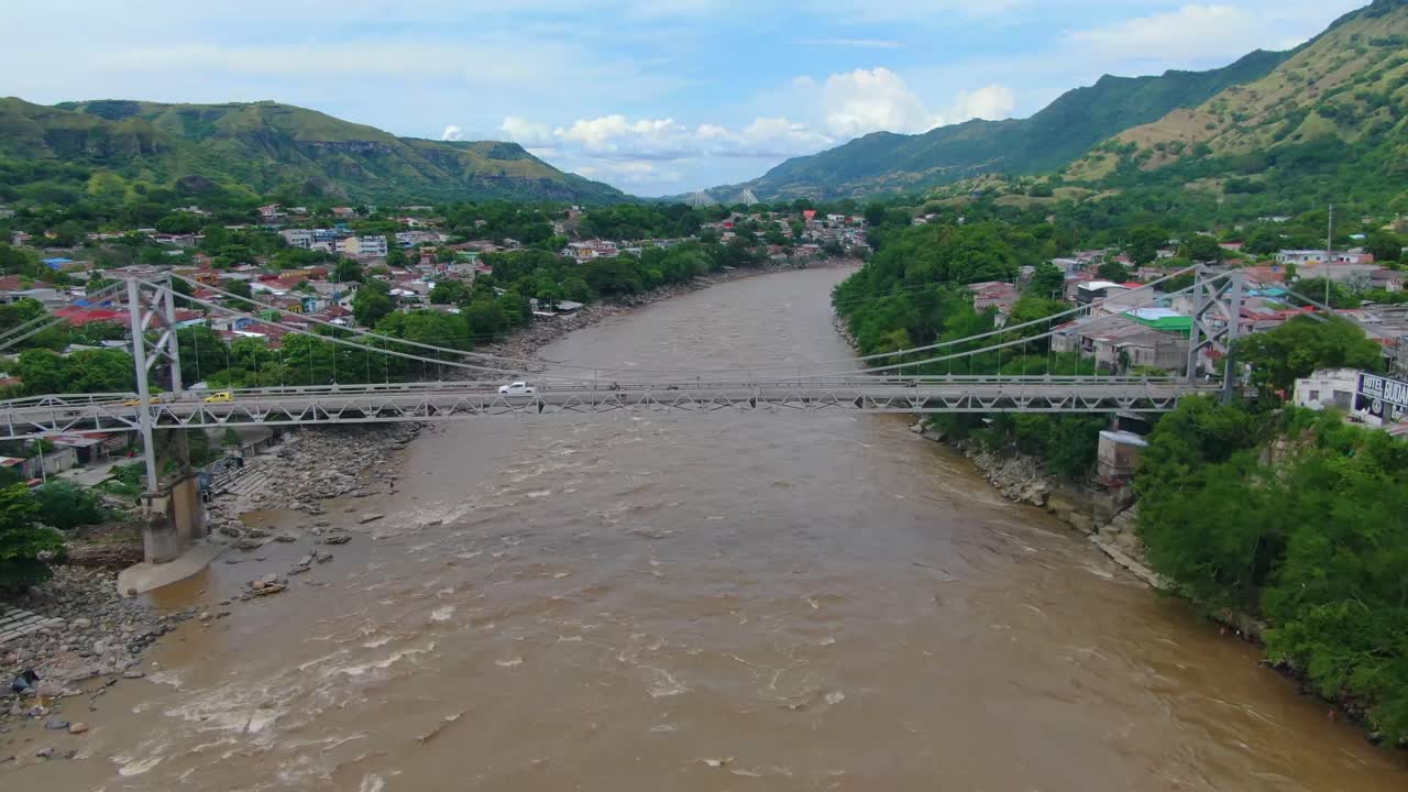gran puente colgante en américa central sobre un río agitado mientras los pájaros vuelan en el cielo