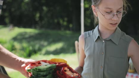 video de seguimiento de la hija ayudando a organizar las verduras en la parrilla