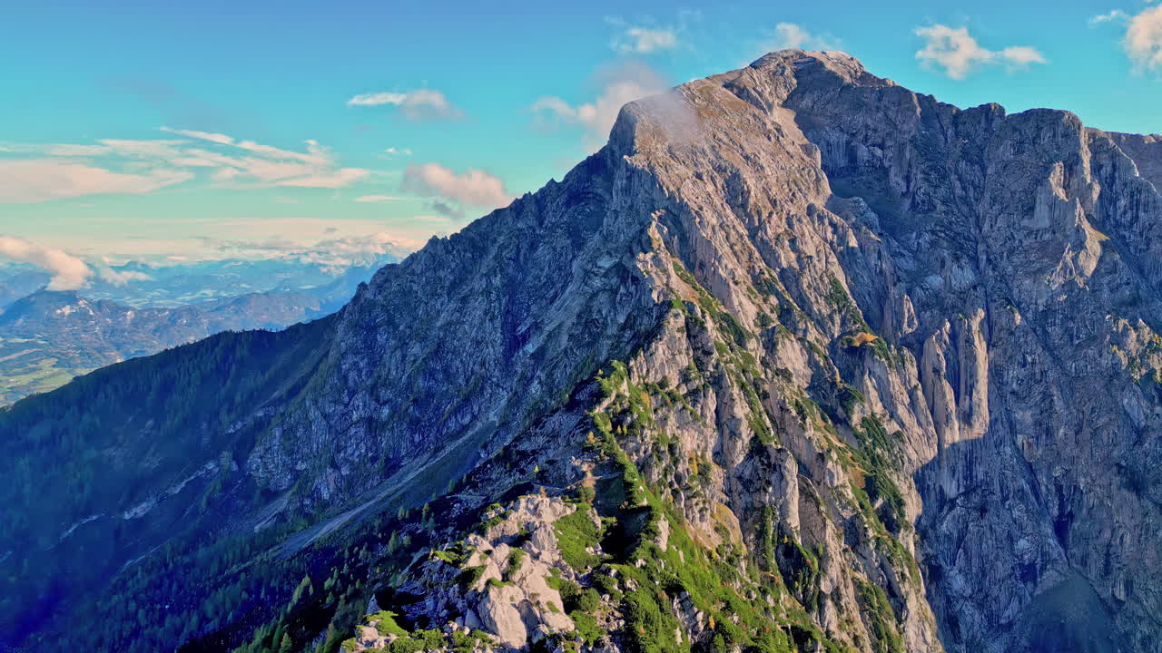 Carrellata aerea in avanti con drone di una cima di montagna rocciosa e ripida