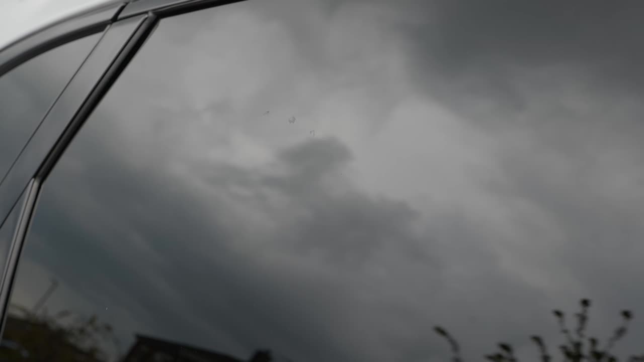 Spraying window cleaner onto tinted car window