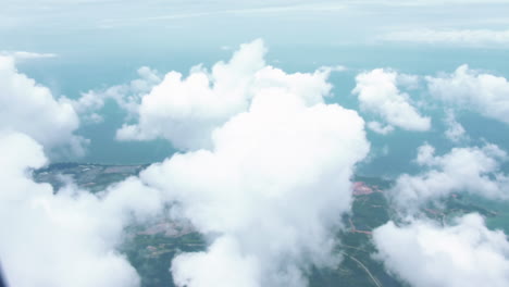 Aerial-View-From-The-Airplane-Flyng-From-Australia-to-Singapore---Flying-Over-The-Layer-Of-Clouds-And-Looking-On-Landscape-Through-The-Clouds---POV