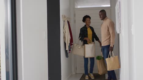 Video-Eines-Glücklichen-Afroamerikanischen-Paares,-Das-Mit-Einkaufstüten-Nach-Hause-Zurückkehrt
