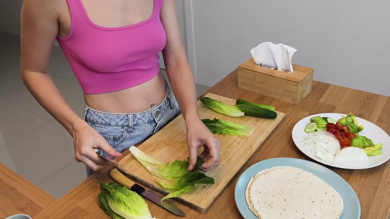 mulher preparando um invólucro com vegetais