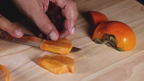 hands slicing persimmon into even pieces