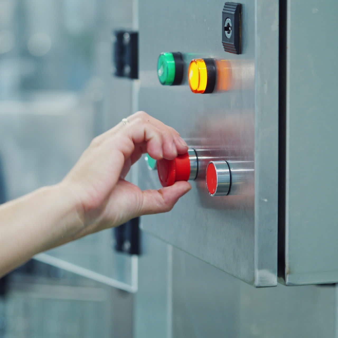 Female starts the work of automated machine in a big modern plant. Worker presses the colorful button of a robotic machine in a dairy factory.