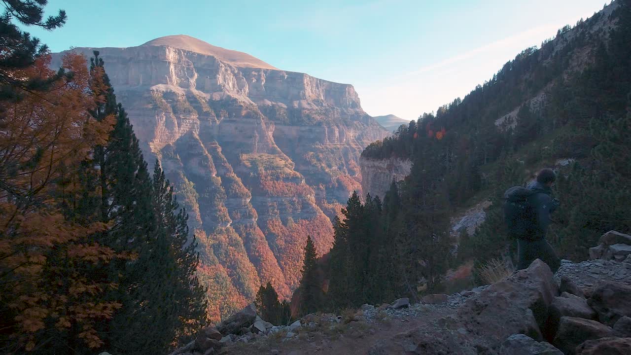 excursionista con mochila de trekking caminando por senderos en bosques otoñales y montañas en el parque nacional de ordesa, españa