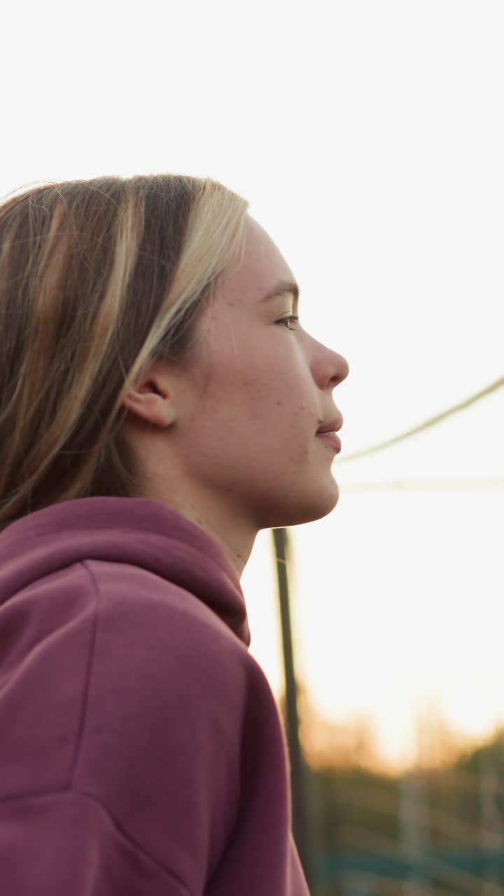 vista lateral de un jugador de voleibol saltando a la pelota de slam con pleno enfoque, red de voleobol visible en el fondo, atleta mostrando fuerza y determinación durante un momento intenso