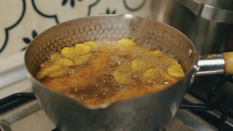 potato chips and chicken legs cooked in hot boiling oil in deep cooking pan