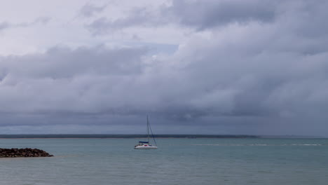 timelapse of storm clouds moving with anchored sailing boat in darwin harbour, northern territory