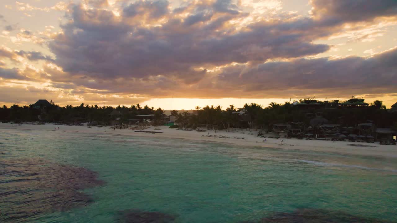 vista aérea sobre la playa de akiin en tulum, méxico mientras la gente disfruta de la puesta de sol en la playa