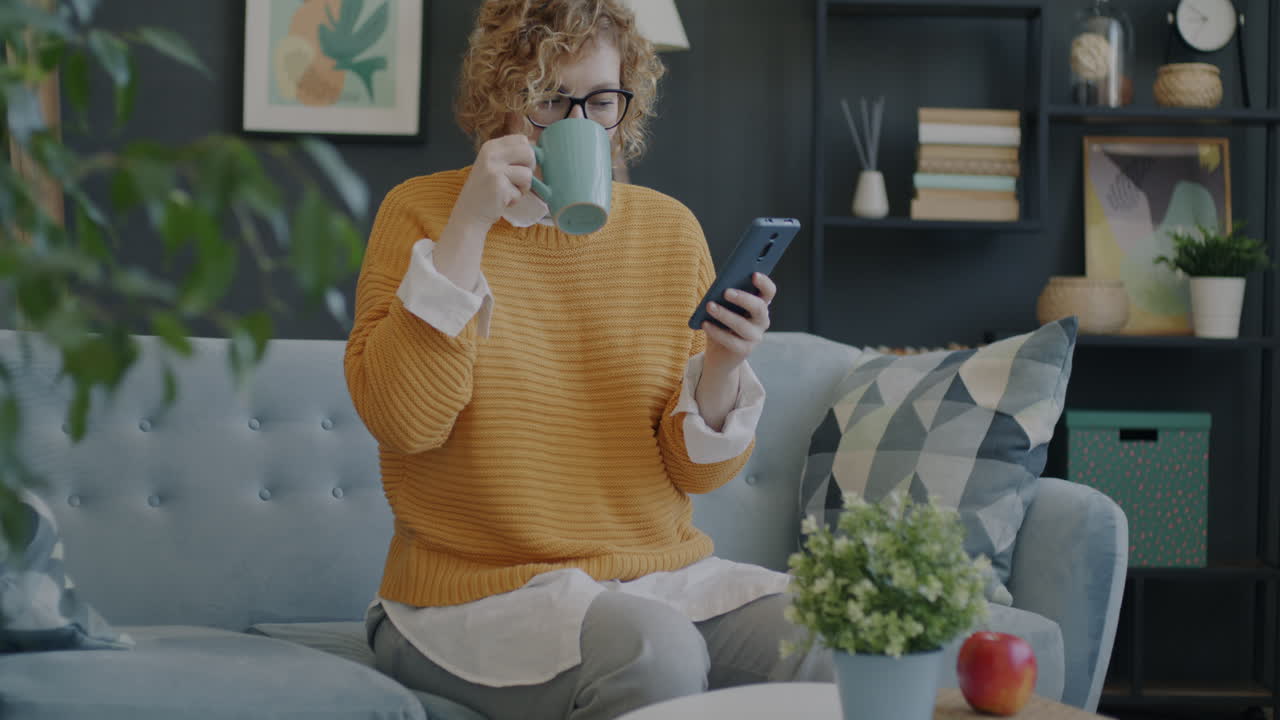 Woman relaxing on couch with coffee and phone